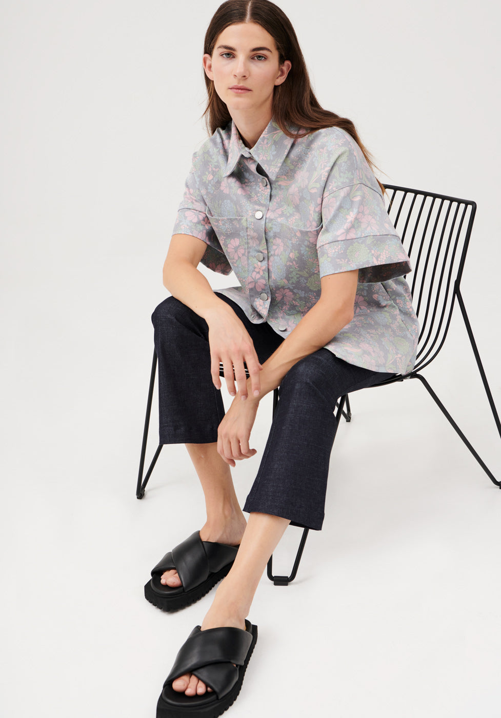 Cuspi Wild Flower Shirt paired with the Kick Flare. Model sitting on a chair. Shop local and explore the latest collection of trans-seasonal styles designed and made in Melbourne, Australia. Cuspi: born on the cusp